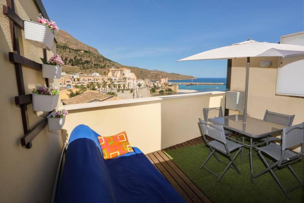 a balcony with a table and chairs and a view of the ocean at La Casa blu sul mare - The Blue house by the sea in Castellammare del Golfo