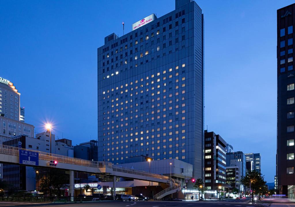 un grand bâtiment avec un pont dans une ville dans l'établissement ANA Crowne Plaza Sapporo, an IHG Hotel, à Sapporo