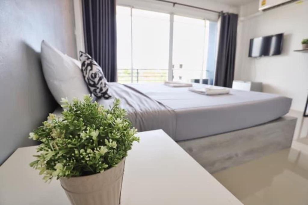 a bedroom with a bed and a table with a potted plant at Rest Point Sampran in Nakhon Pathom