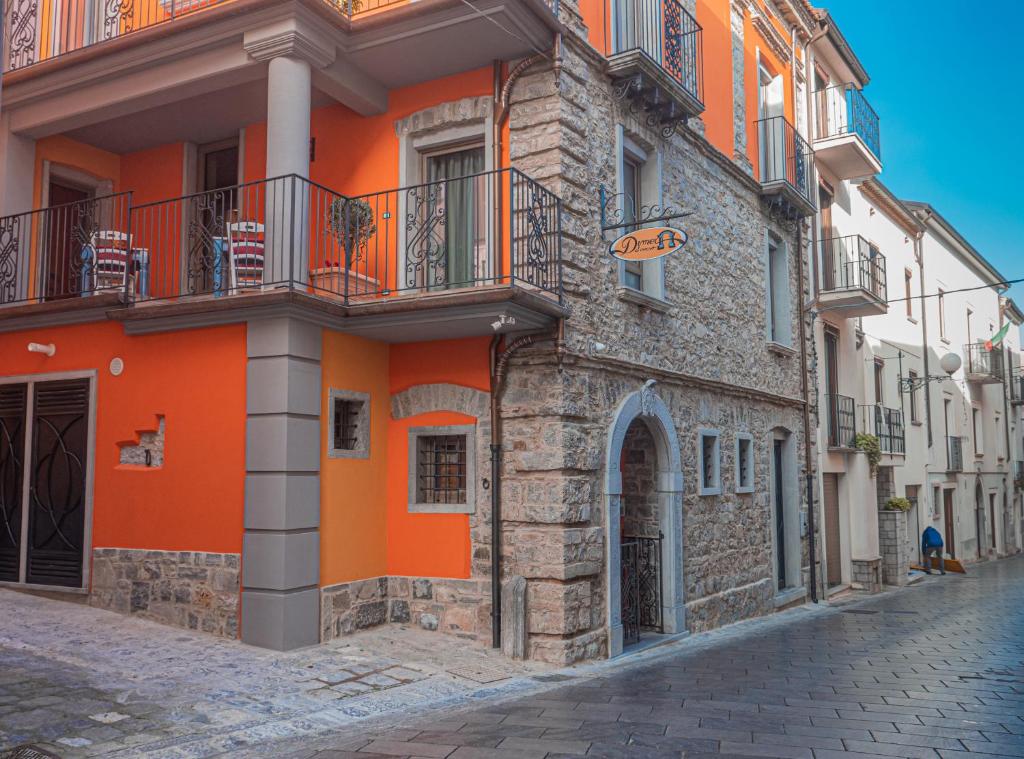 um edifício laranja e branco numa rua em Dimora Del Corso em Rotonda