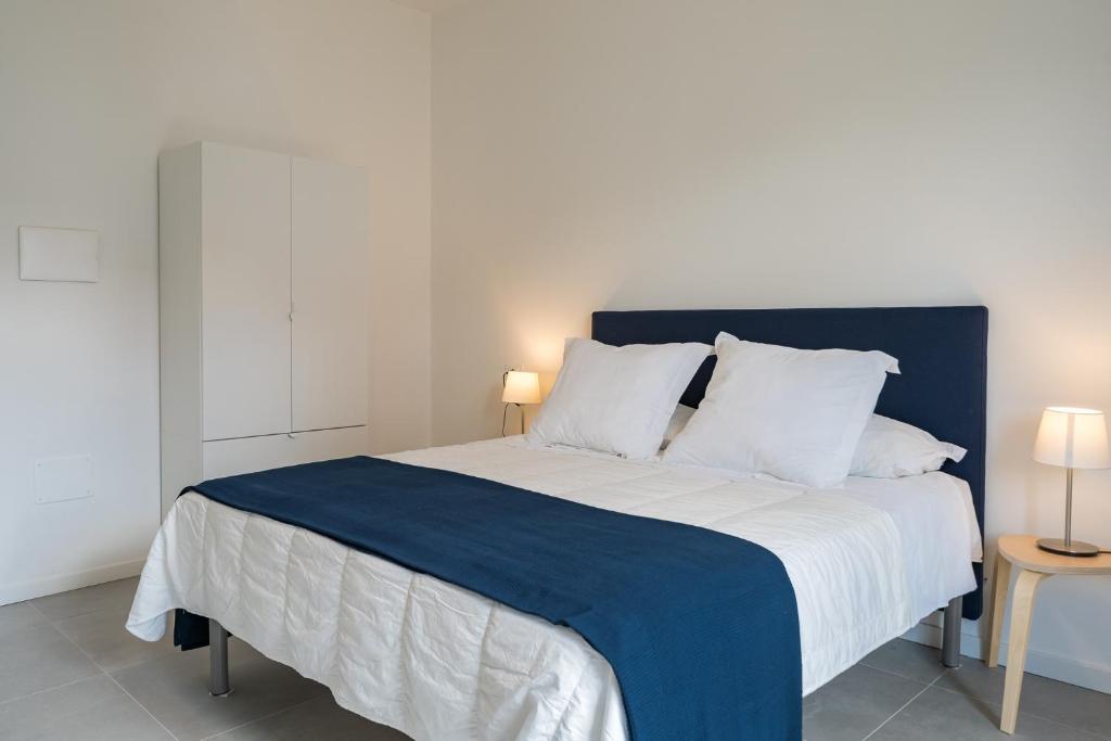 um quarto com uma cama azul e branca com 2 candeeiros em Marèe b&b em Agropoli