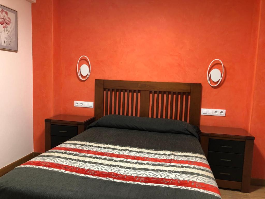 Schlafzimmer mit orangefarbenen Wänden, einem Bett und zwei Spiegeln in der Unterkunft APARTAMENTO MEXICO 6 (VIGO CENTRO) in Vigo