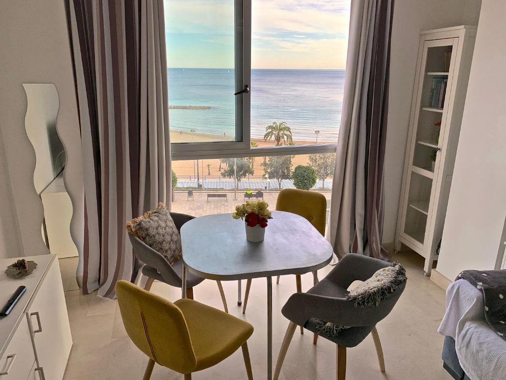 a room with a table and chairs and a view of the ocean at POSTIGUET BEACH in Alicante
