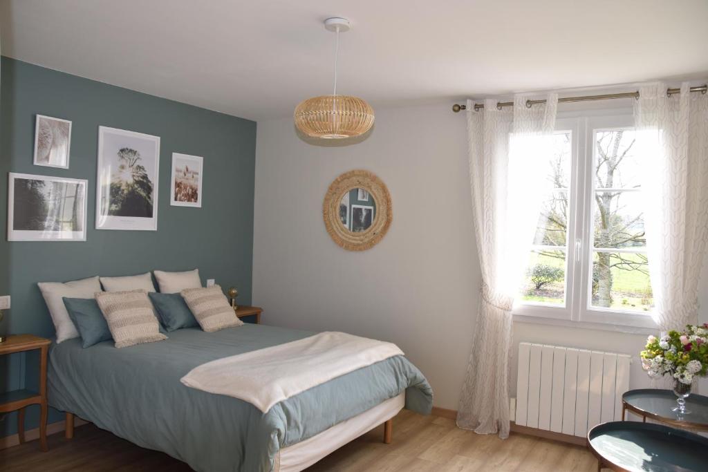 a bedroom with a bed and a window at Les Rougemonts Eucalyptus in Champguyon