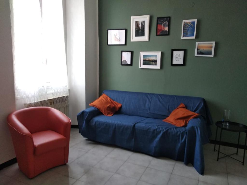 uma sala de estar com um sofá azul e uma cadeira vermelha em Casa Lucia em Lavagna