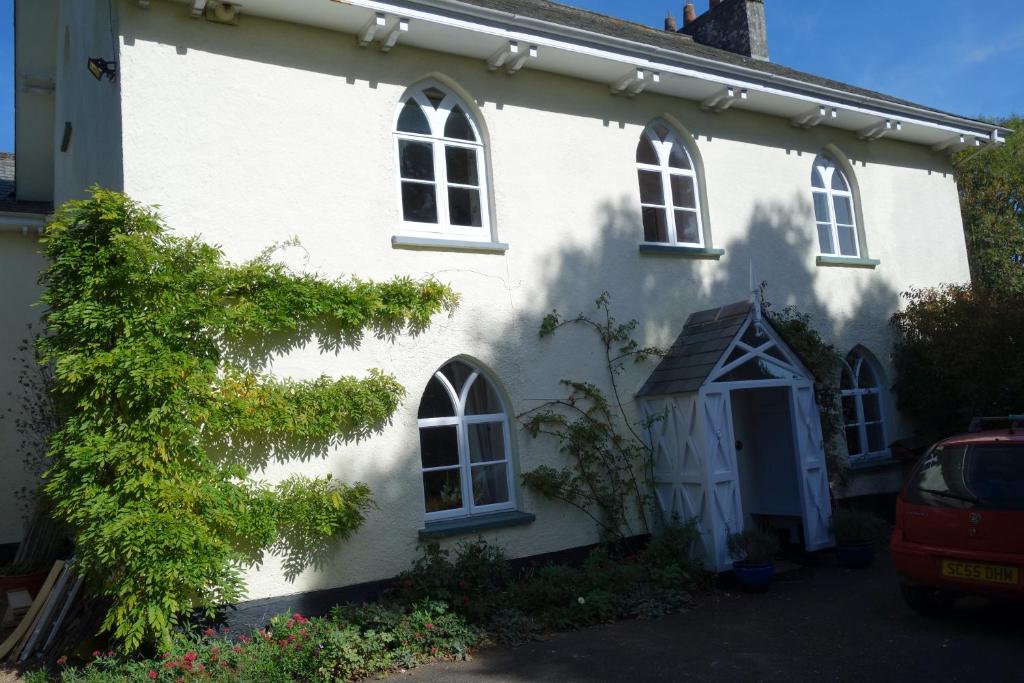 una casa bianca con molte finestre di St Michaels House a Crediton