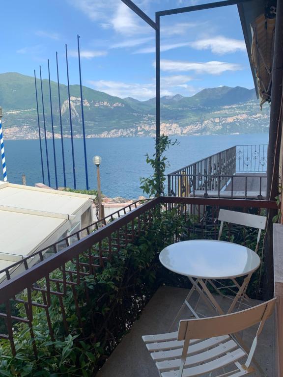 カステッレット・ディ・ブレンゾーネにあるCasa Italiaのテーブルと椅子、水辺の景色を望むバルコニー