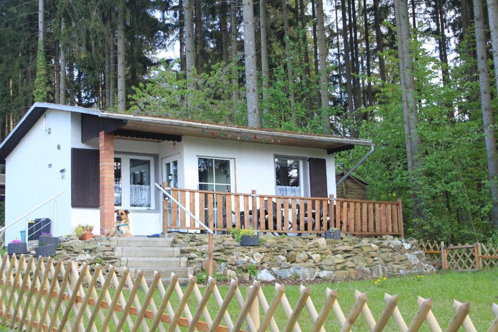 une petite maison blanche avec une clôture devant elle dans l'établissement Zum-Seehörnchen Haus Fuchs, à Tanna