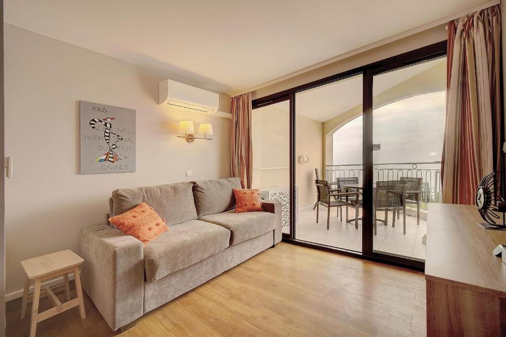 un salon avec un canapé et une table dans l'établissement IMMOGROOM - 2 Rooms sea view - Swimming pool - Terrace - Parking - AC, à Cannes