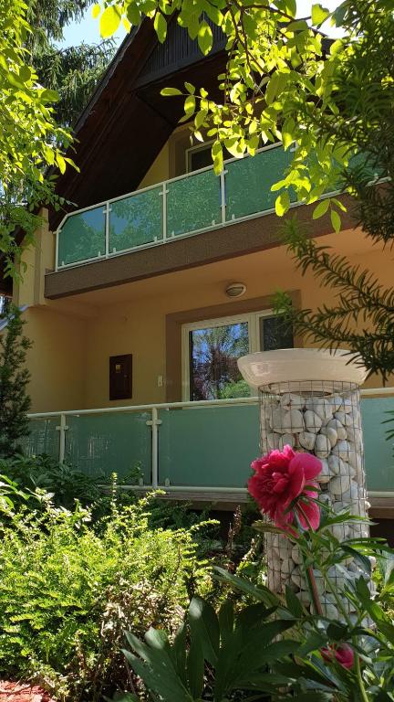 una casa con balcón y una flor en el patio en Keller Apartmanok, en Hajdúszoboszló