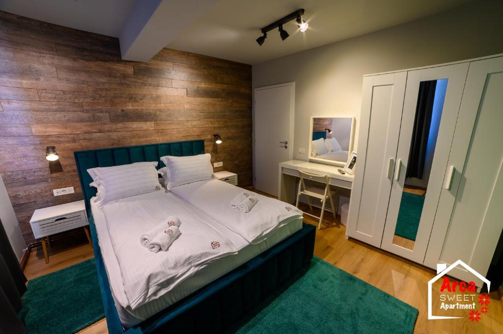 um quarto com uma cama com um urso de peluche em Arca Sweet Apartment Ariniș em Gura Humorului
