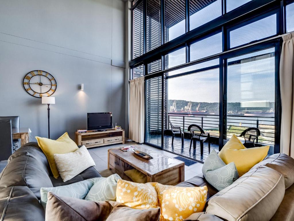 a living room with a couch and a large window at Point Bay - Super Stylish for Less in Durban