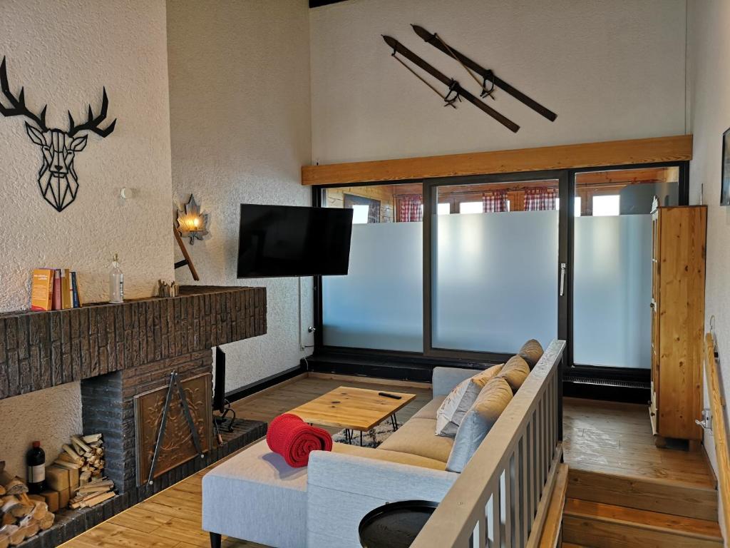 een woonkamer met een bank en een open haard bij PENTHOUSE Appartement Bergliebe Sankt Englmar in Sankt Englmar