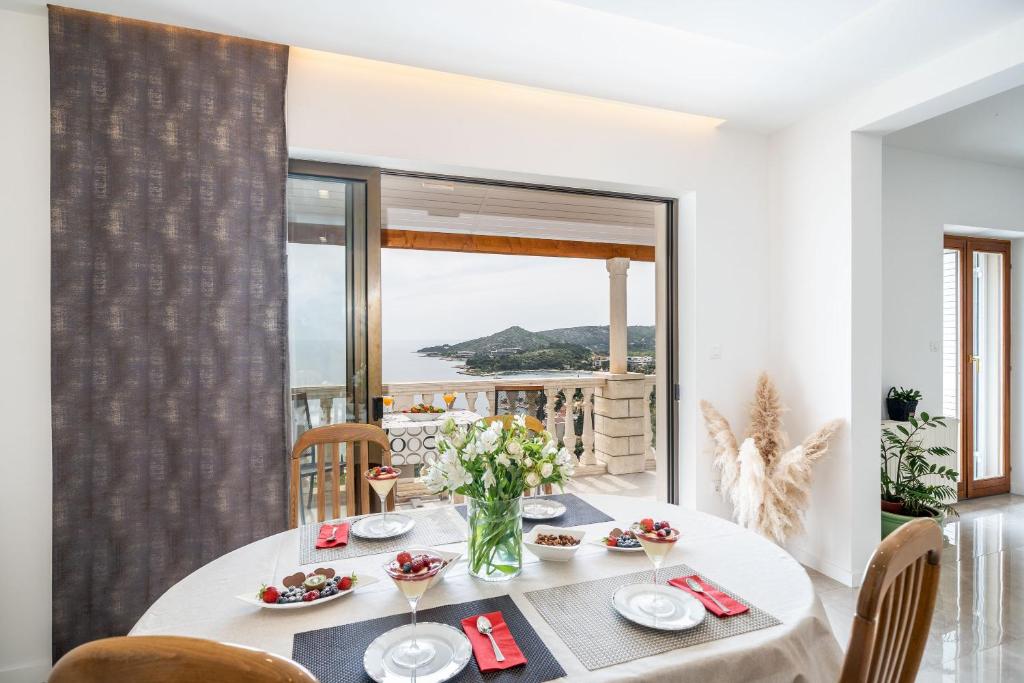a dining room with a table with a view of the ocean at Deluxe apartment in Mlini