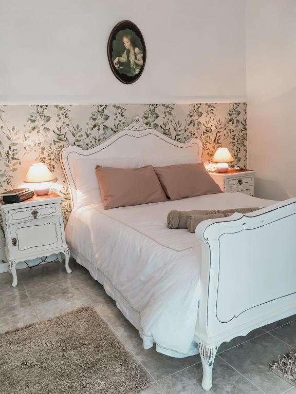 a bedroom with a white bed and two night stands at Casa do gato branco in Furadouro