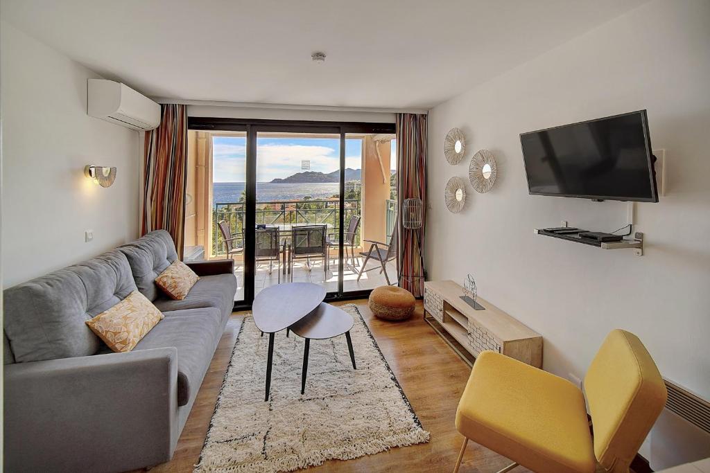 un salon avec un canapé et une télévision dans l'établissement IMMOGROOM - 2 Rooms - Renovated - Pool - Parking - Air conditioning -, à Cannes