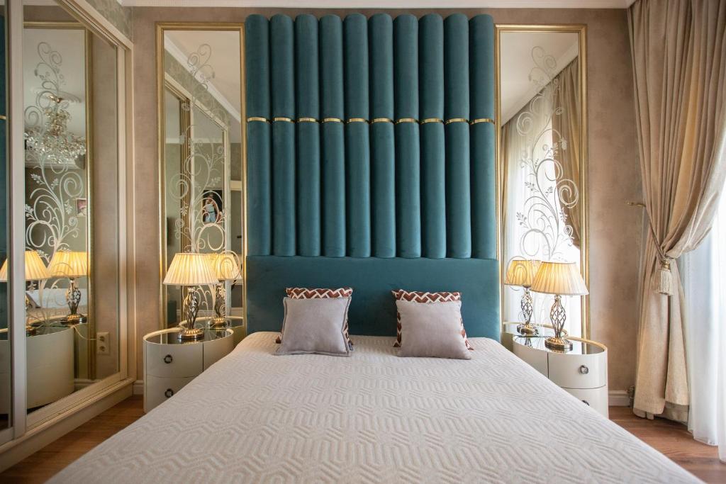 een slaapkamer met een groot bed met een blauwe muur bij Beach & Beatles Apartments in Odessa