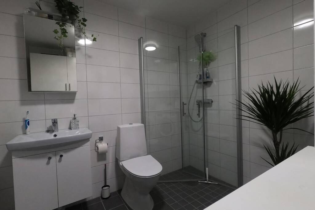 a bathroom with a shower and a toilet and a sink at Homestay - private room in an apartment in Gothenburg