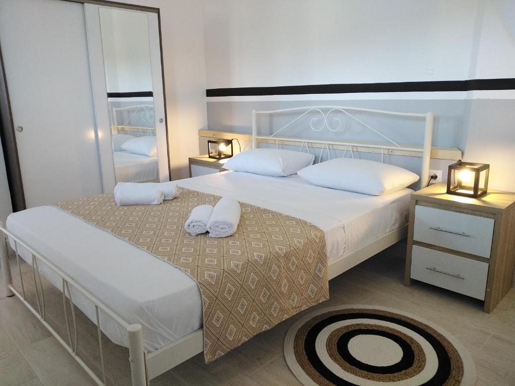 a bedroom with two beds and a large mirror at Apartment 2 for rent in Tzanata Kefalonia in Dhimisianáta