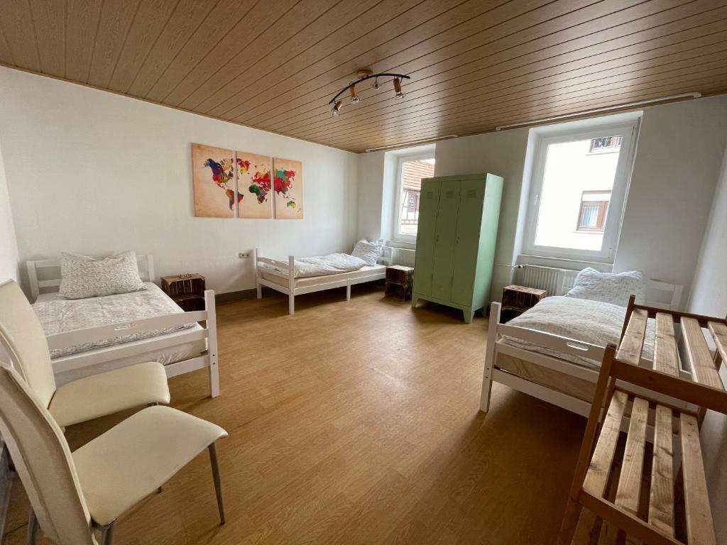 een kamer met 2 bedden en een groene kast bij Das Baumeisterhaus - Monteurzimmer in Grünberg in Grünberg