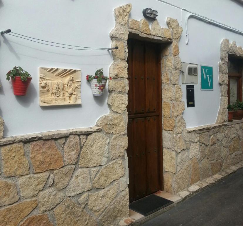 una puerta en una pared de piedra con macetas en V.V Casa Mones, en Cangas de Onís