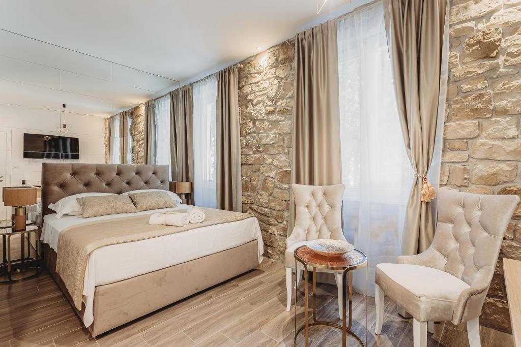 a bedroom with a bed and a stone wall at Four Elements in Split