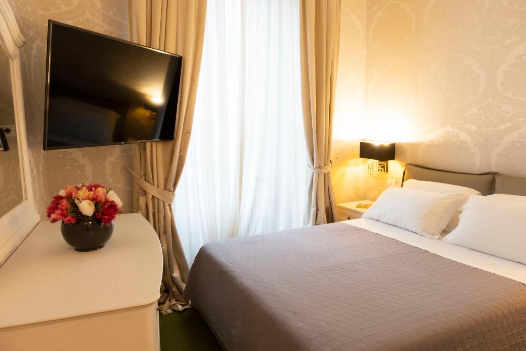 a hotel room with a bed with a vase of flowers at Cathy's Luxury Home in Rome