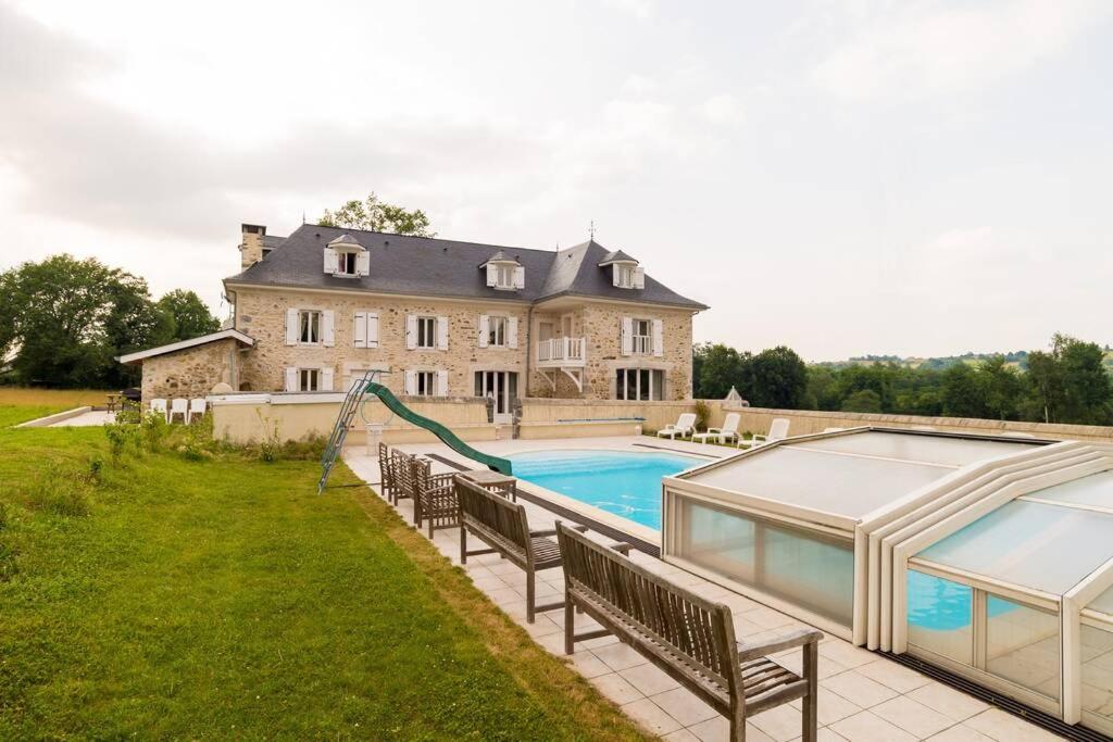 a large house with a swimming pool and a house at Maison harmonie in Buzy