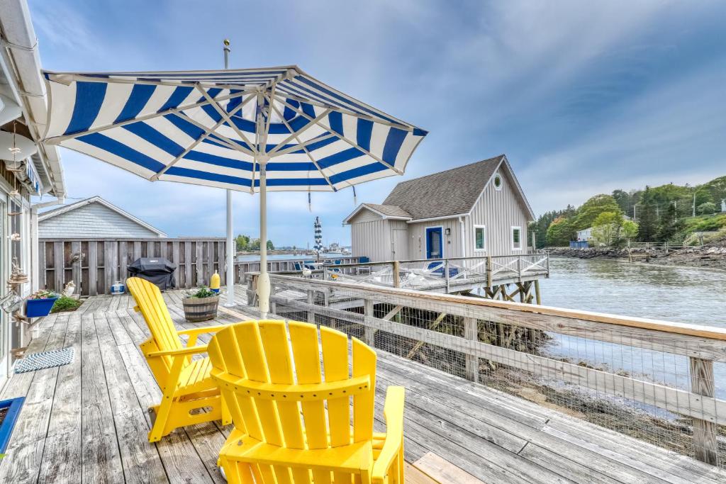 a dock with two chairs and an umbrella at Sweet Haven in Boothbay Harbor