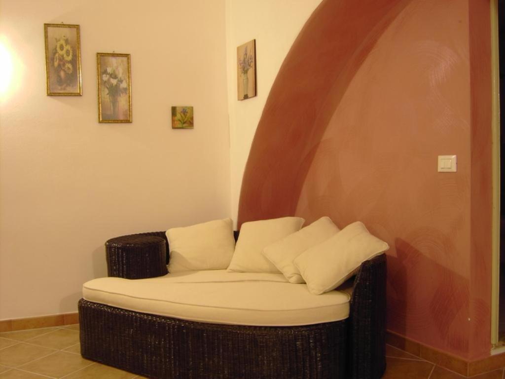 um sofá de vime com duas almofadas sentadas num quarto em Girasole home em Trapani