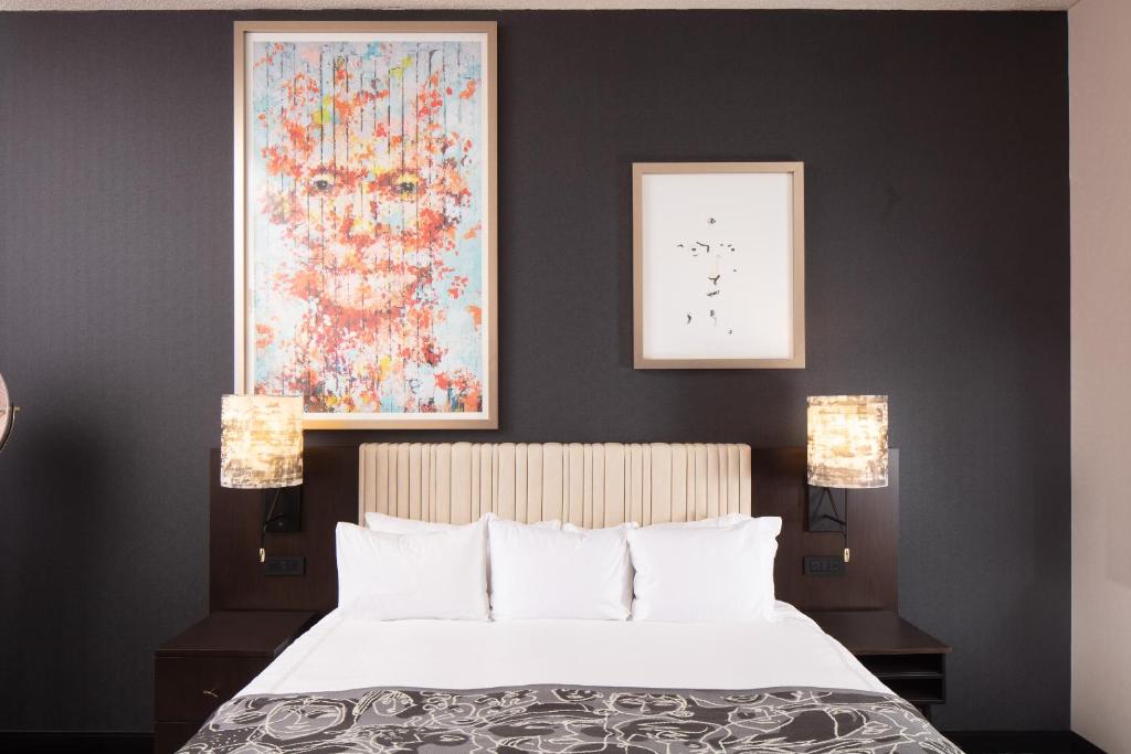 a bedroom with a bed with two lamps and a painting at Saint Kate - The Arts Hotel in Milwaukee