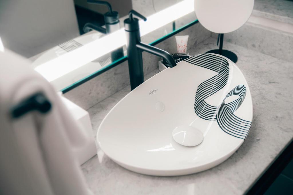 a bathroom with a toilet with a towel on it at Saint Kate - The Arts Hotel in Milwaukee