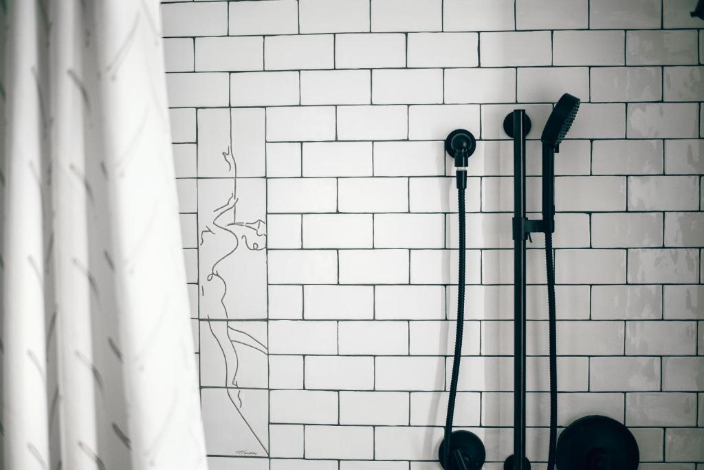 a white tiled wall with two hair brushes at Saint Kate - The Arts Hotel in Milwaukee