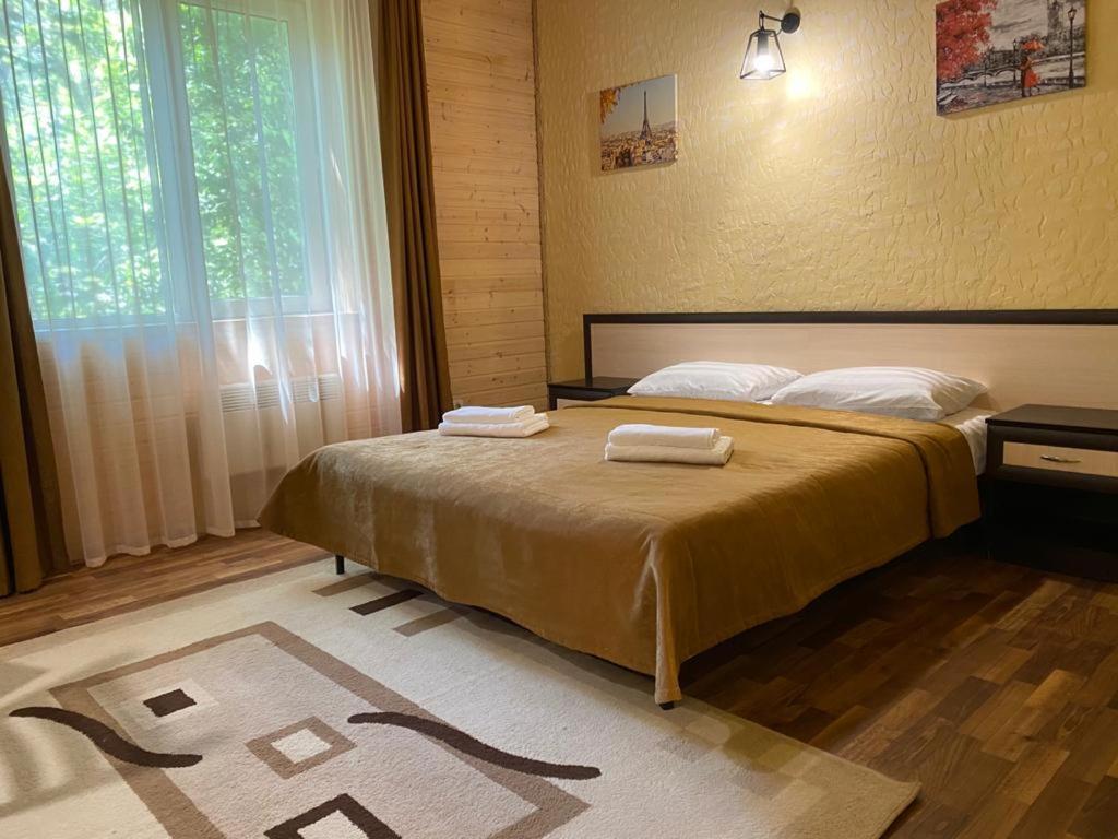 アルヒーポ・オシポフカにあるGuest House Adelのベッドルーム1室(ベッド1台、タオル2枚付)