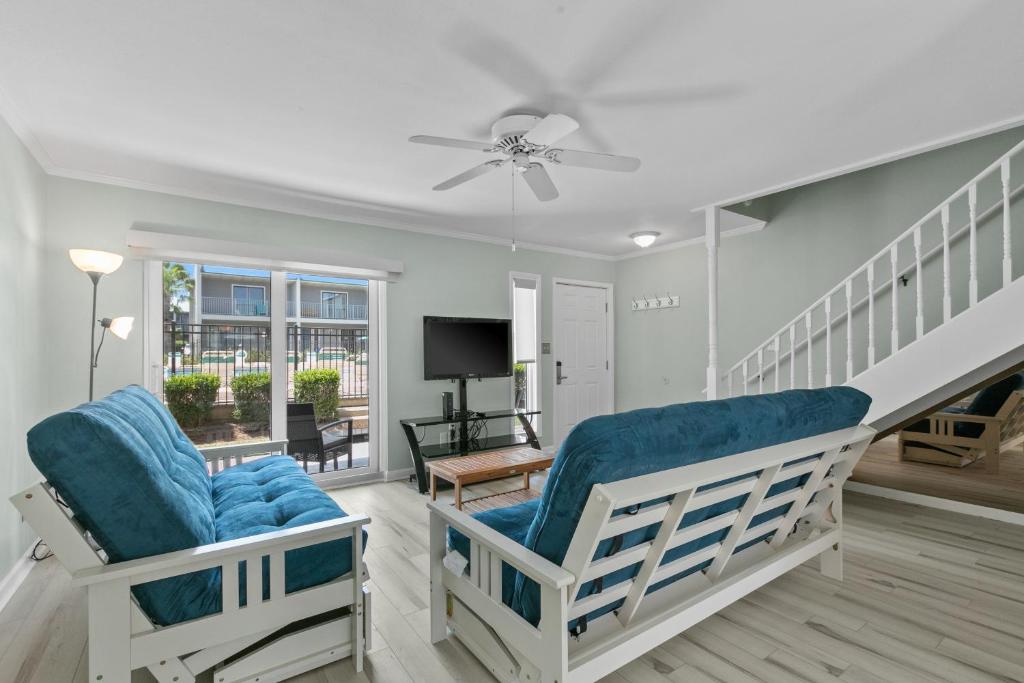 sala de estar con 2 sillas y ventilador de techo en Gulf Winds #25, en Destin