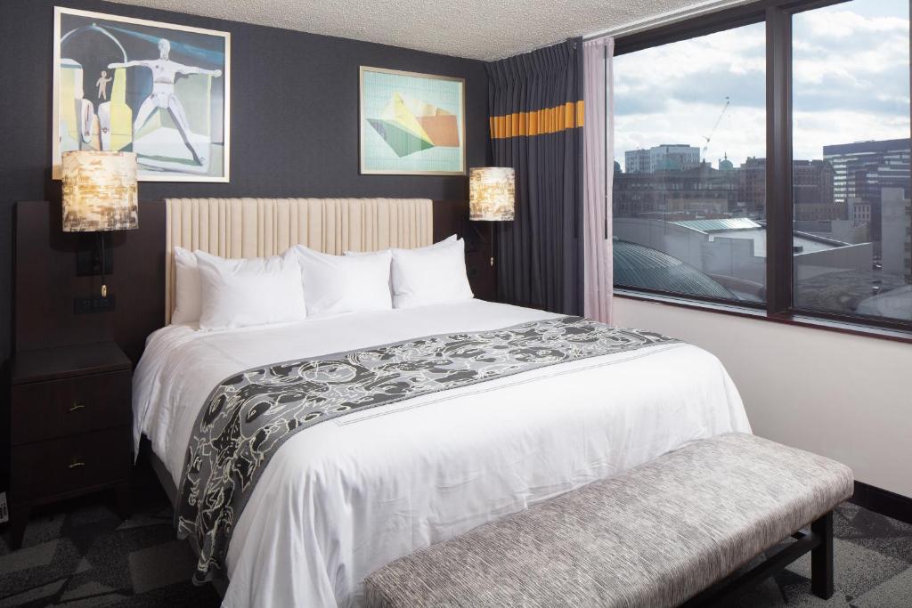 a hotel room with a large bed and a window at Saint Kate - The Arts Hotel in Milwaukee