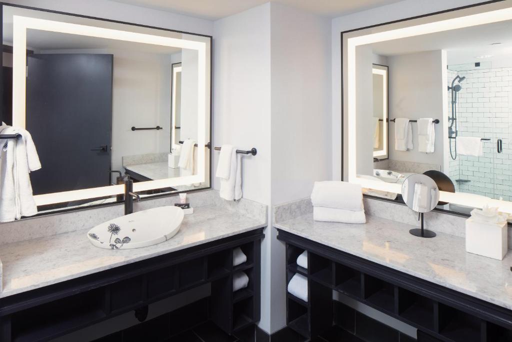 a bathroom with two sinks and a large mirror at Saint Kate - The Arts Hotel in Milwaukee