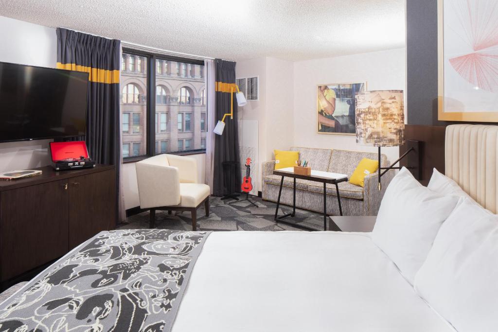 a hotel room with a bed and a living room at Saint Kate - The Arts Hotel in Milwaukee