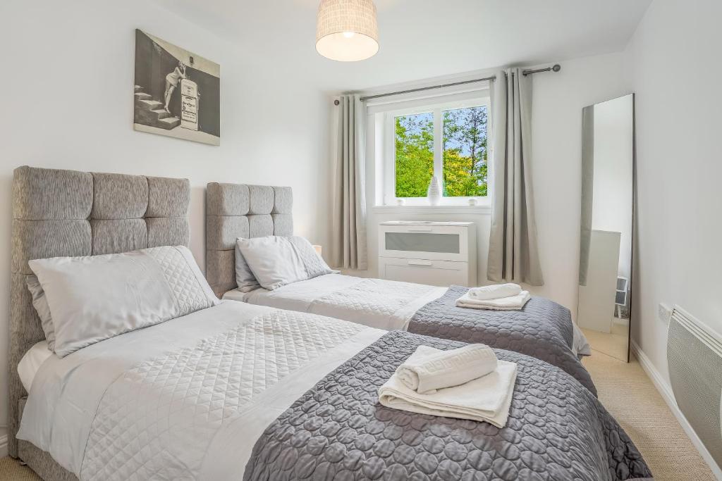 a bedroom with two beds and a window at Saughton Suite in Edinburgh