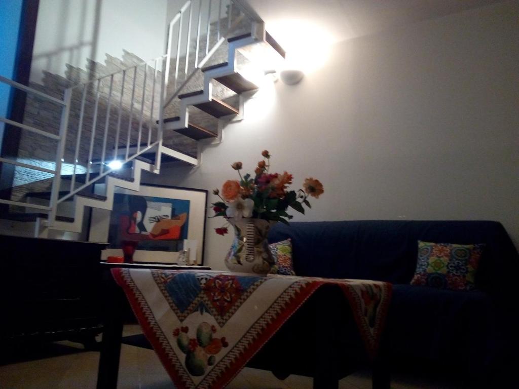 un canapé bleu avec une table et un vase de fleurs dans l'établissement casa maravigghia, à Catane