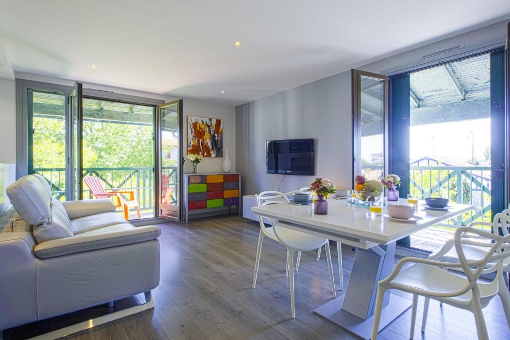 - un salon avec une table et des chaises dans l'établissement Modern flat with three balconies in Biarritz - Welkeys, à Biarritz