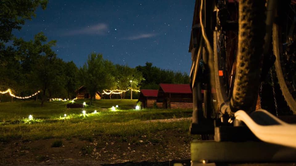 a vehicle parked in a field at night with lights at La 3 stejari, Călimănești in Sălătrucel