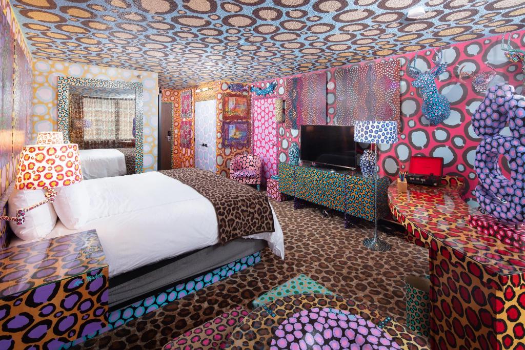 a bedroom with a bed and a room with colorful walls at Saint Kate - The Arts Hotel in Milwaukee