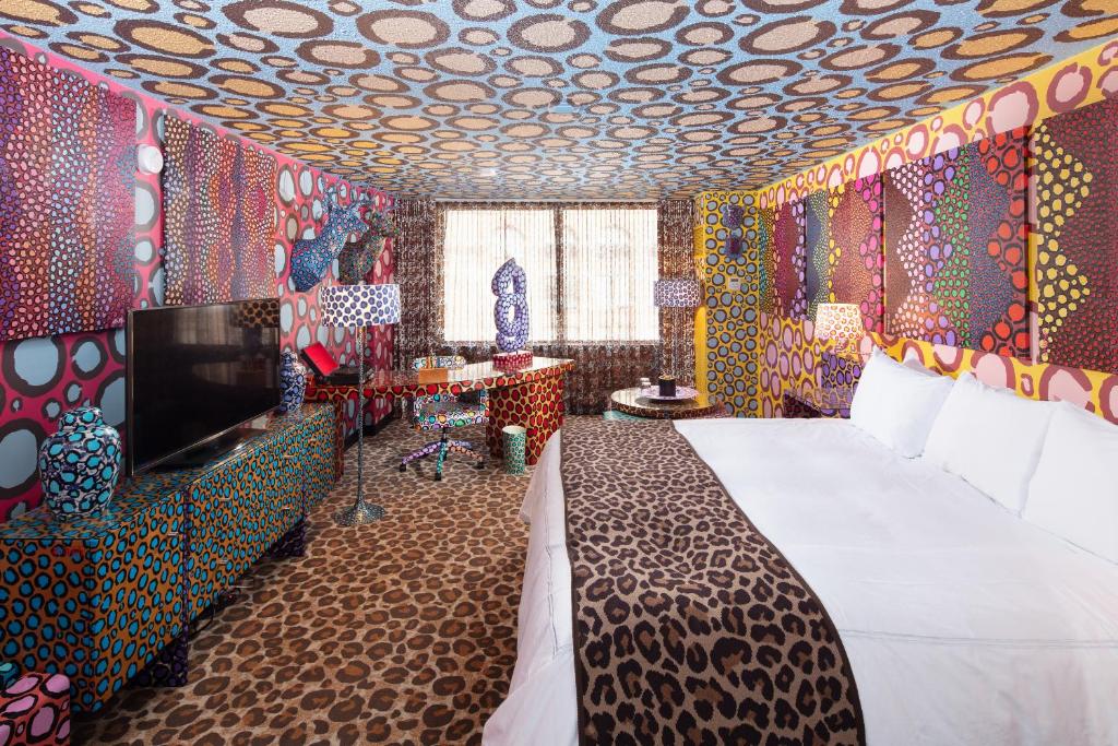 a bedroom with a bed and a tv and colorful walls at Saint Kate - The Arts Hotel in Milwaukee