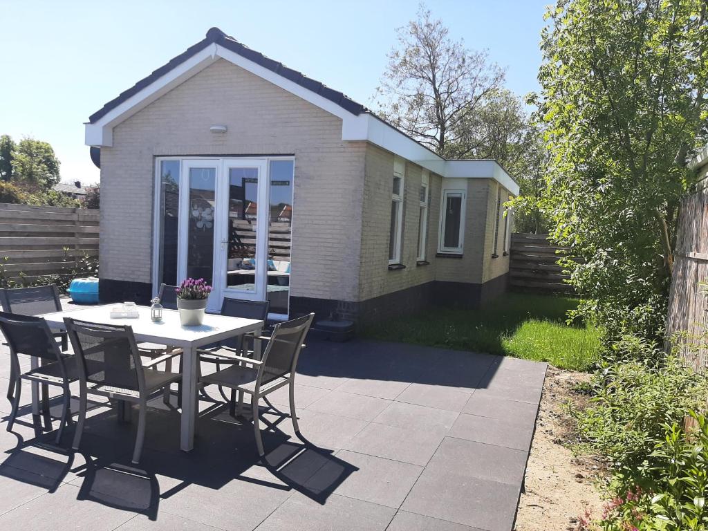 een patio met een tafel en stoelen voor een huis bij Huisje Britt park de Horn in Dirkshorn