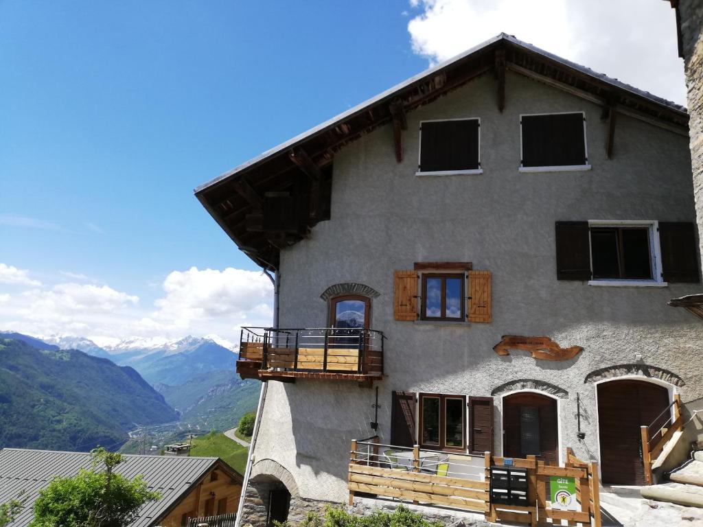 a house with a balcony and mountains in the background at Maison de l'Epine -spa- Versant du soleil in Granier