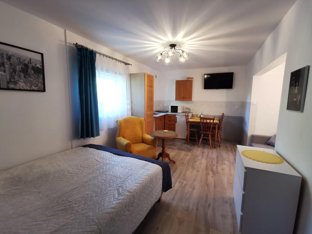 sypialnia z łóżkiem i stołem oraz kuchnia w obiekcie Apartament Ogrodowa we Fromborku