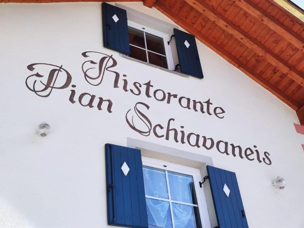 a sign on the side of a building with a window at Pian Schiavaneis B&b apartament in Canazei