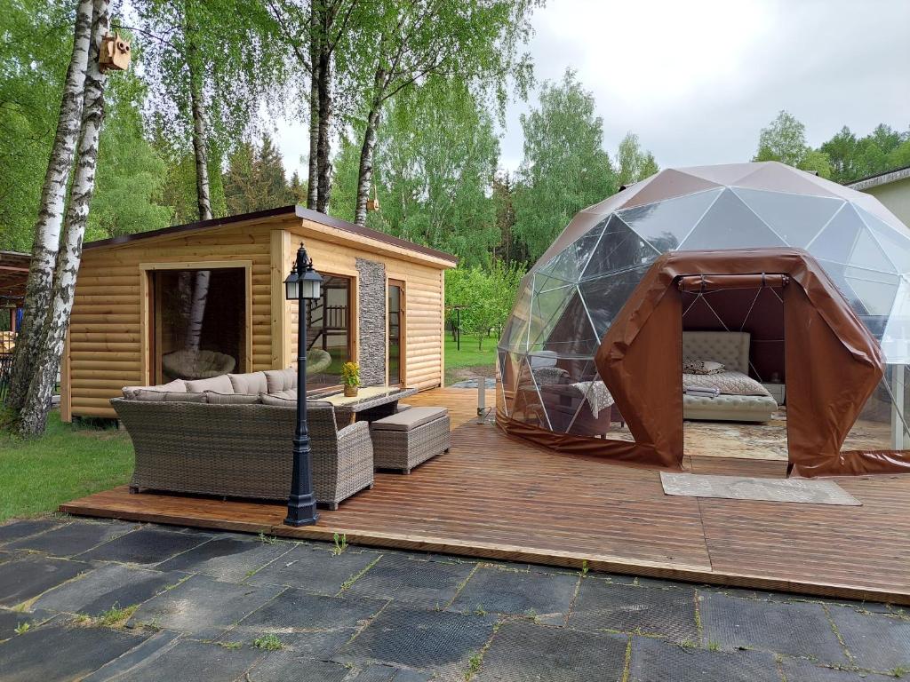 namiot i kanapa na drewnianym tarasie w obiekcie kupolas w Szawlach