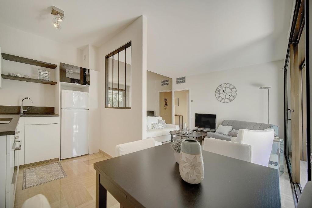 a kitchen and living room with a table and chairs at IMMOGROOM - Close beaches - Terrace with sea view - pool -AC in Cannes